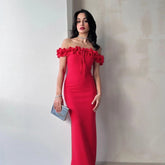 Woman wearing a red off-shoulder dress against a plain background